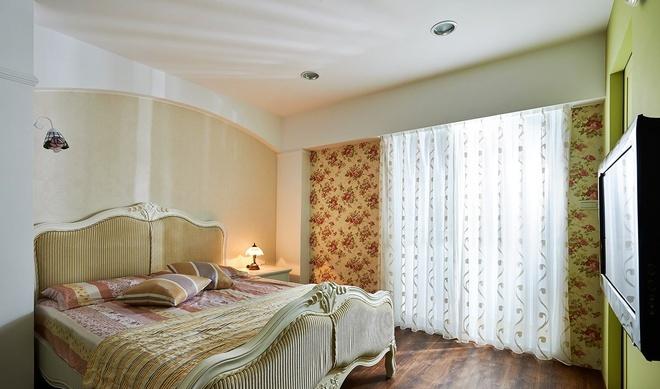 舒适大床与碎花窗帘是最佳搭配，绿色墙壁让卧室的格调大大提升。