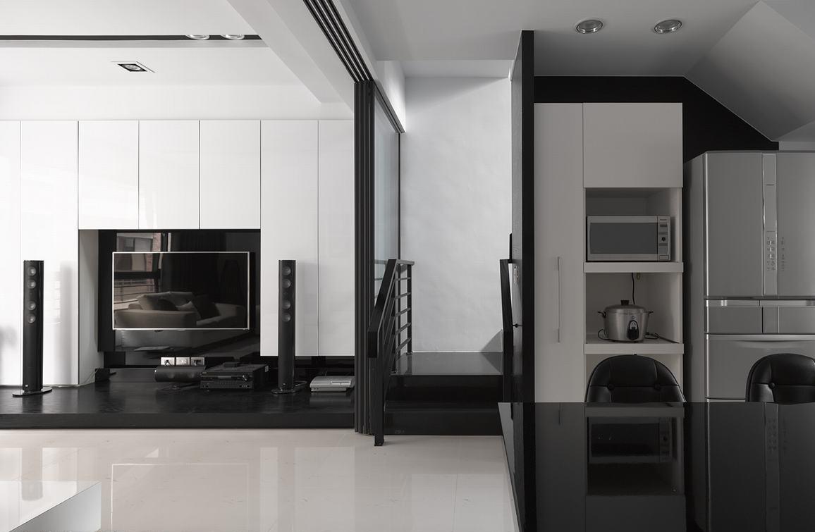 客厅电视墙采用白色烤漆处理，而中段的楼梯也有了黑色的的对应位置，空间上正好与餐厅厨房的场域有了齐面式一致画面。
