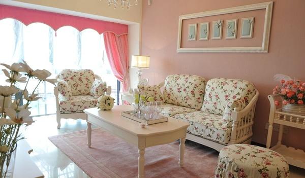 明亮的客厅铺着粉色的地毯，象牙白色的茶几散发高雅的气质，淡雅的碎花布艺沙发，营造出一个温馨、优雅的客厅。