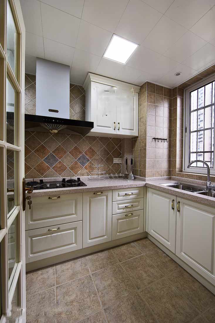 采用白色的整体橱柜，让厨房清爽整洁。大面积的采用大理石瓷砖，有一种传统美式厨房的感觉。