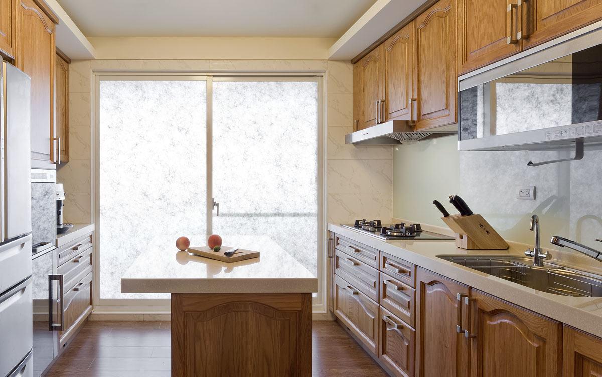 夹纱玻璃阻绝了后阳台晒衣间景物，映入眼帘的实木厨具明亮洁净。