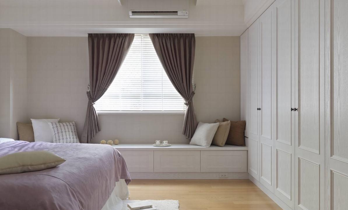 白色及美式风格延伸来到主卧房空间，在不动格局的考量下，设计师利用床尾衣柜及窗边平台满足了收纳。