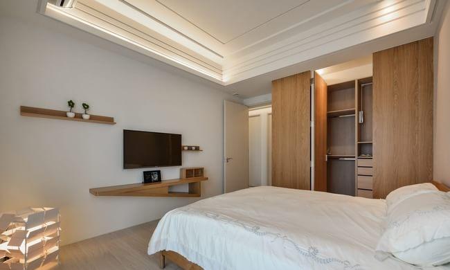 主卧也是简约的设计，木质色彩的储物柜和搁物架，简洁的线条和色彩创造舒适的睡眠空间。