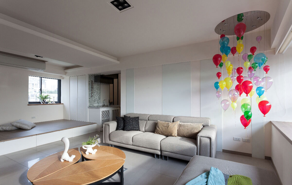 圆形挖空的天花板吊挂彩色气球吊灯，成为空间的主视觉，搭配叶子造型活动式桌子，为空间带来趣味性。