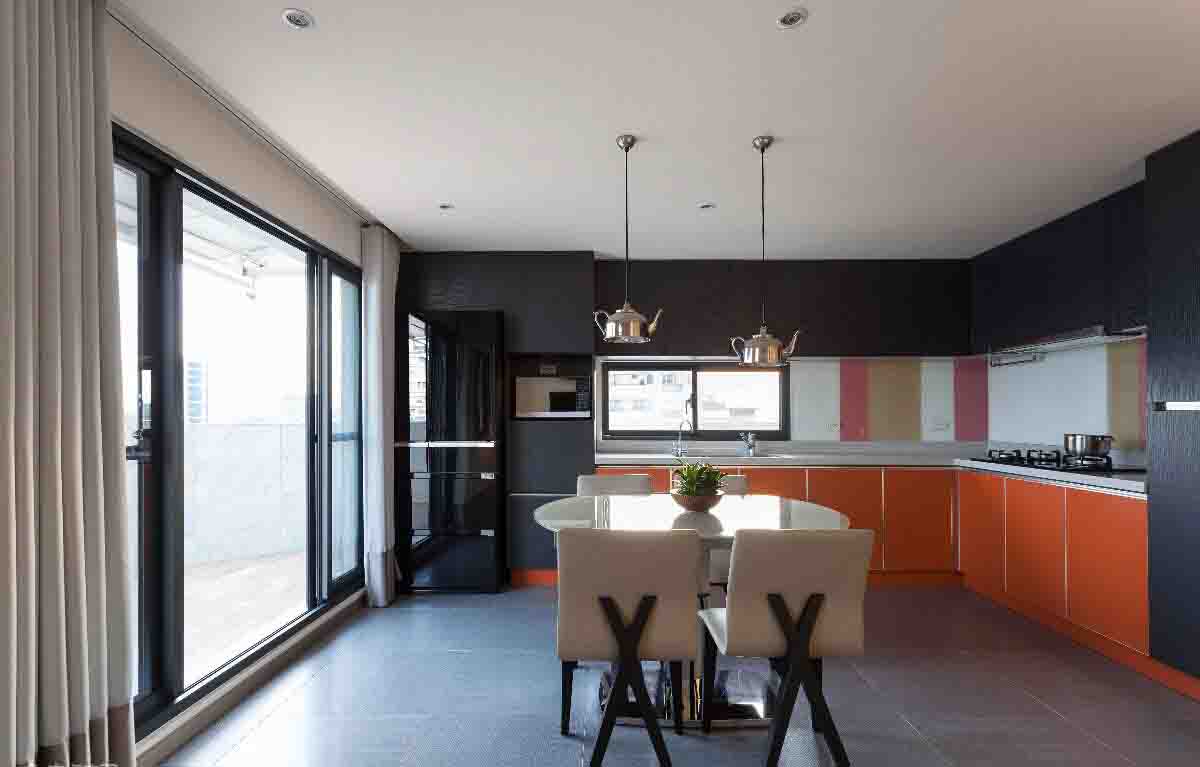 选用橘色厨柜搭配缤纷色的烤漆玻璃壁面以及茶壶造型的吊灯，活泼新颖。