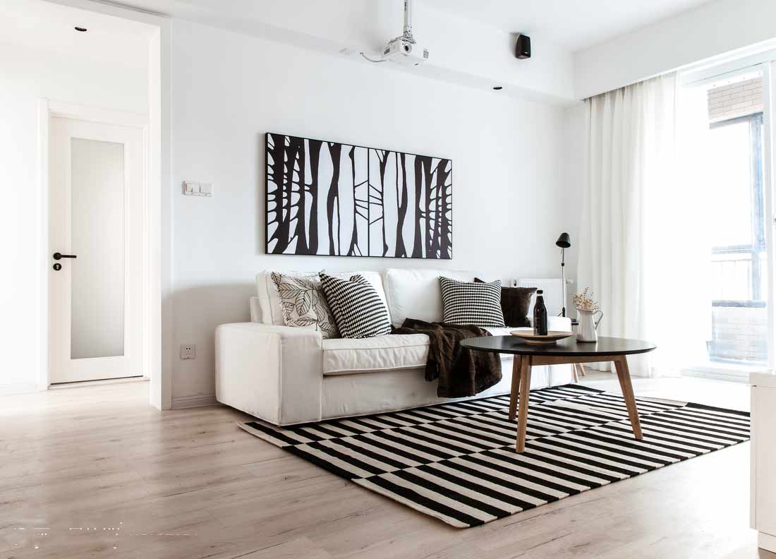 白色的墙面和地板上，家具和艺术品都选择了深色，对比十分鲜明，各个部分的轮廓也由此更加清晰。