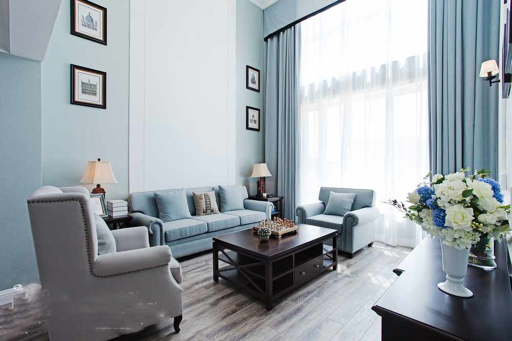 房屋最重要的空间肯定是面积比例大的客厅区域。浅蓝色的墙面让空间显得舒适而宁静，更在视觉上起到了“扩张”空间的作用。空间中的所有家具饰品，都是设计师精心选择的。深褐色的家具在空间中，让空间显得沉稳而大气。