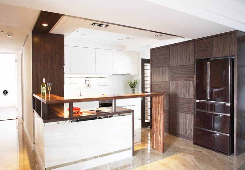厨房的设计选用了暗色与白色相结合、既带有储藏效果也有装饰美观性的橱柜。吧台作为区域间的隔断有效提高了空间的利用率。