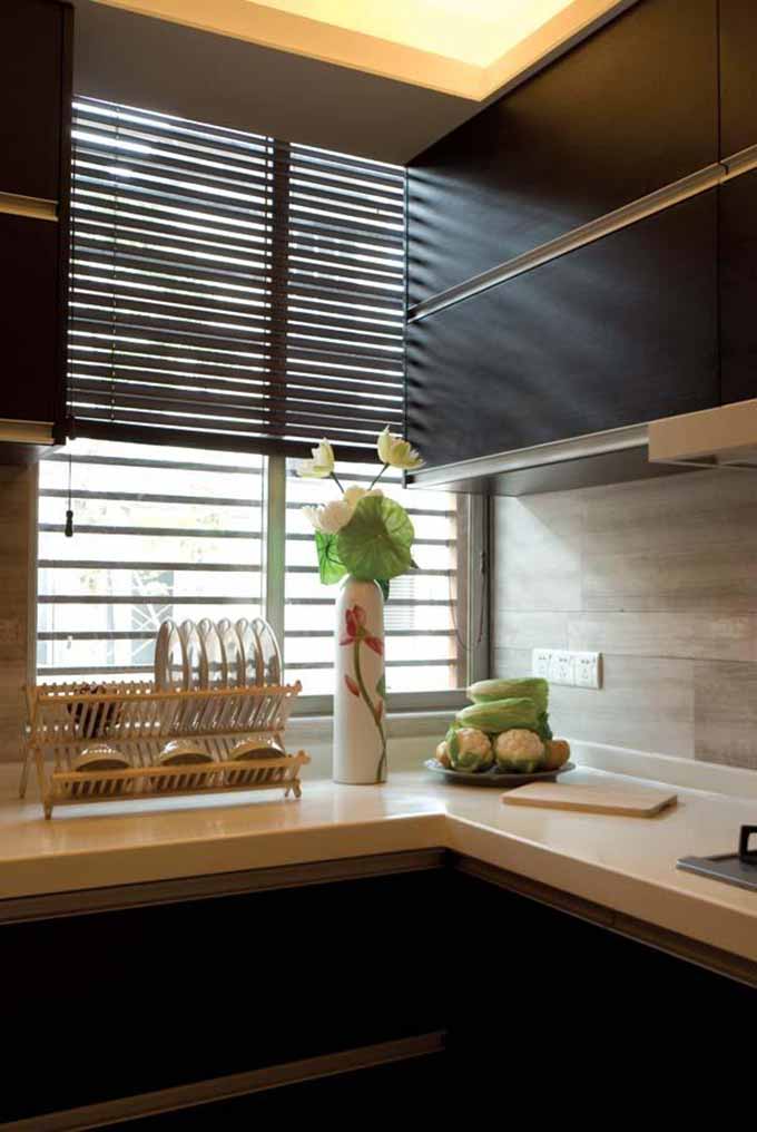 厨房十分简洁，白色的台面与深色的厨柜形成对比，相得益彰。
