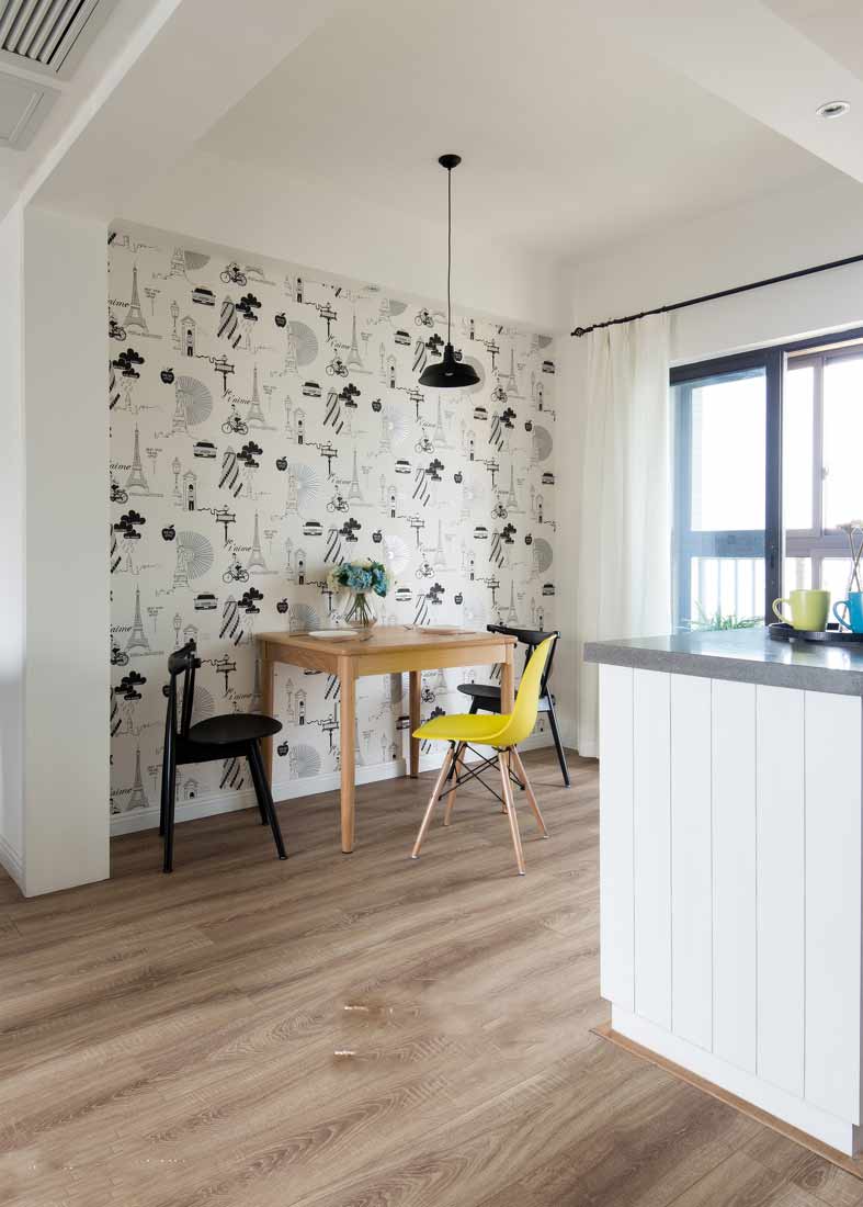 餐桌的墙面用的是多图案的墙纸，减少了单调感。木质的餐桌与木地板相称。