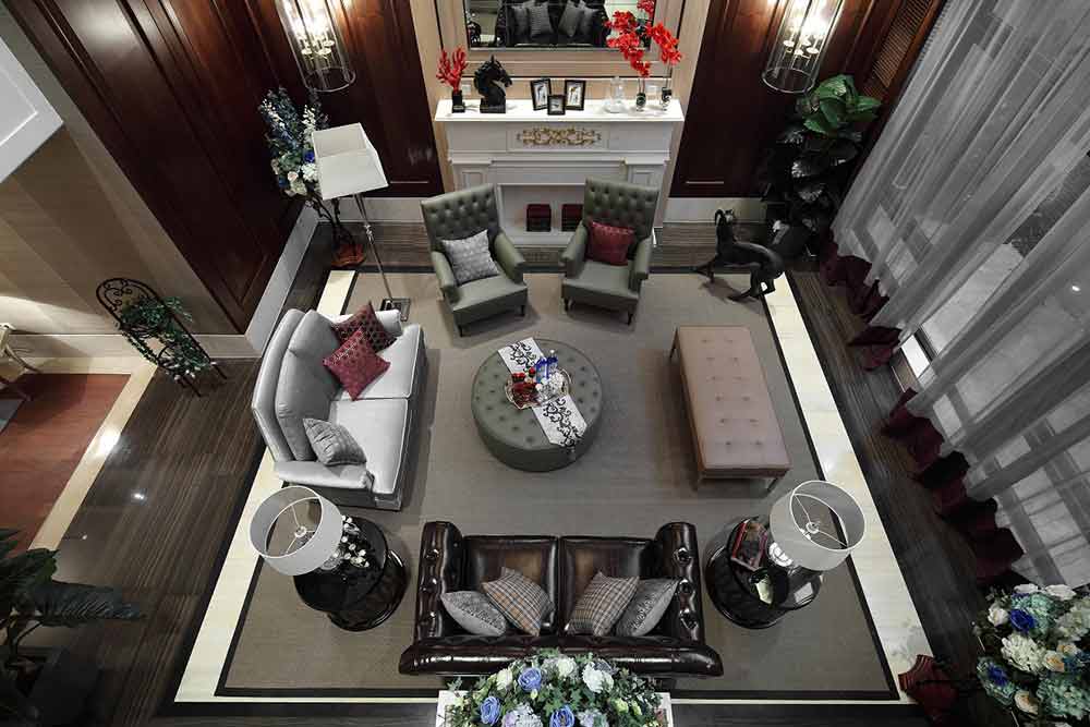 俯瞰客厅，各式家具依照中心陈列，错落有致。一块方正的灰色地毯将所有的高端质感包容其中。