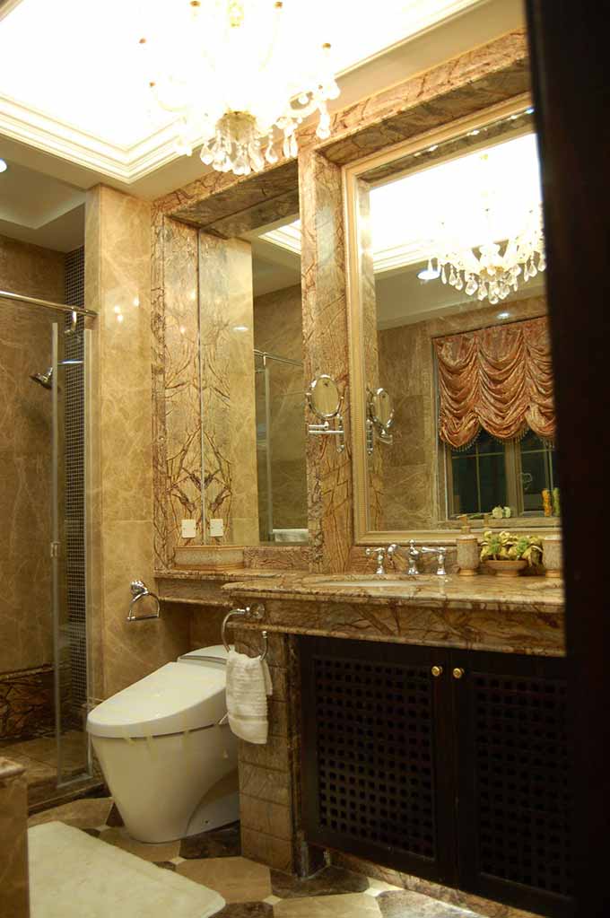 华美而不刻意的天然瓷砖纹路将卫生间装饰得精致典雅，设计师特地扩大了镜子的使用面积，以起到增大整个空间的视觉效果。