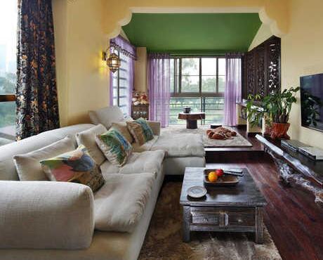铁灰色茶几是客厅内的亮点，在暖色系的黄色，绿色墙面中显得理智而沉静。
