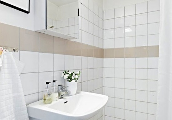 浴室的设计较为紧凑，许多地方做了隐藏式收纳设计，比如镜子被嵌入储物柜中，毛巾架则放在了马桶背后，充分利用了空间。