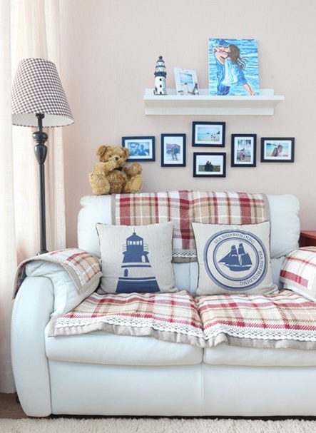 客厅里一张小小的白色双人沙发显得简洁明快，红白格子的坐垫既可以防脏又添了不少活泼气氛，夫妻二人的生活照片与小搁板组成了简单而温馨的沙发背景墙，地面上的白色地毯有着舒适的质感。