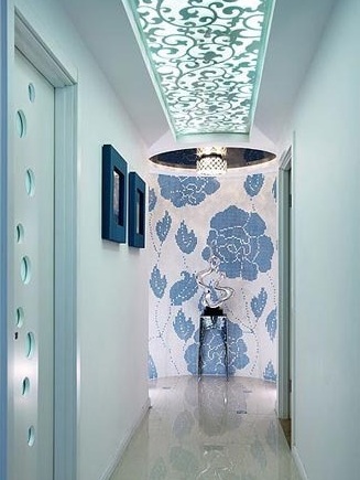 走廊尽头的这面背景墙采用了蓝白马赛克拼花的方式。吊顶采用了与客厅隔断相仿的雕花板的造型，优雅又别致。