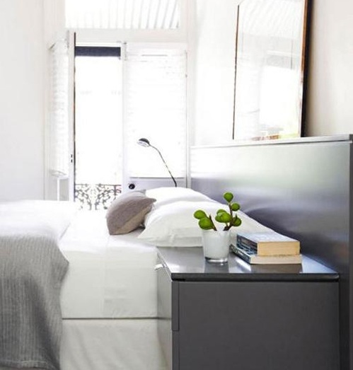 简单的卧室也是灰白主色调，卧房内没有多余的装饰，该图展示一套简洁的组合床搭配一幅清新的挂画。整个公寓都以灰白色为主要装饰色调，显得个性时尚。