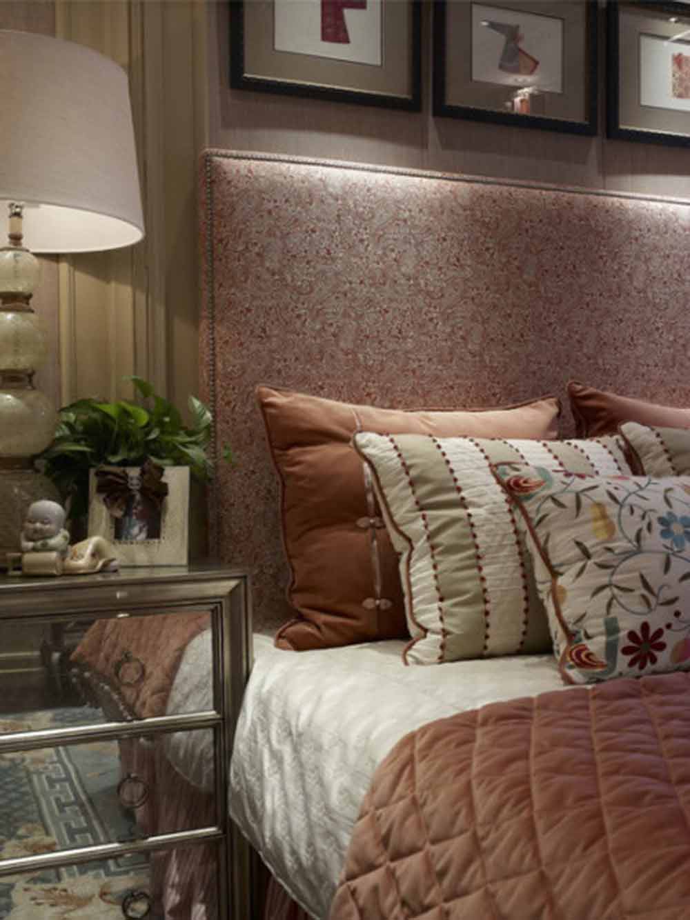 次卧主要采用较为素雅的风格，以橙色调营造了温暖舒心的起居空间。壁画、灯具的选择也较为简洁可爱。