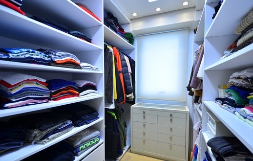独立的衣帽间采用分层收纳的方式，整齐便利。不易折叠的衣物挂在靠里面的空间，节省了较大的空间。中间白色的收纳柜则用于存储小衣物，让人不得不感叹主人的细心。