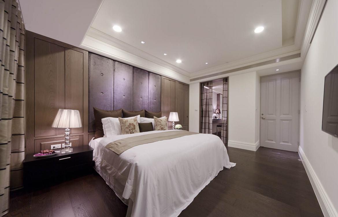 卧室里的木质床头板一直铺满了整个空间，低调的卡其色装点空间特别沉稳。