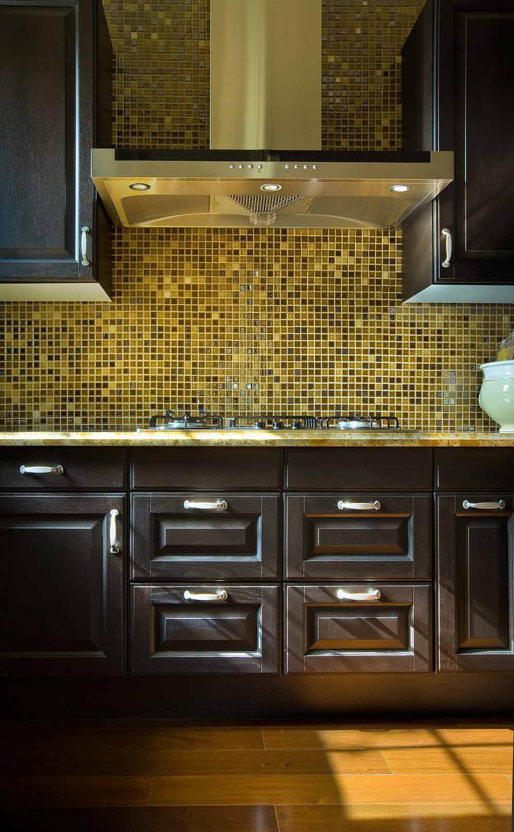 深色的厨房往往更易于清洁和整理，而为了避免空间过于沉闷，墙壁铺贴大面积马赛克，给人一种阳光照射般的闪耀感。