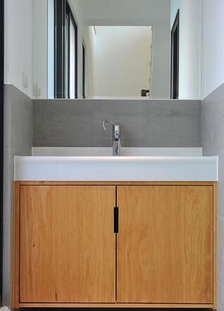 设计师在洗手台下方订做的浴柜，增强了卫浴的收纳机能。