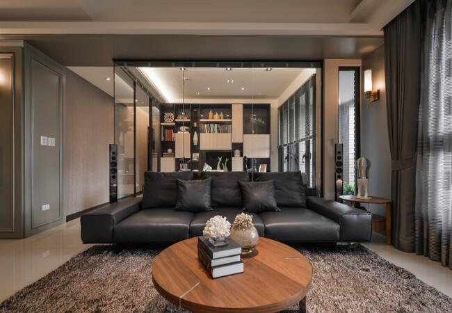 选择极具现代感的家私，为空间增添了直观的时尚色彩与温暖触感，沙发背后以玻璃作为区域隔断，直接可以穿透看到后面的各种设计，丰富了整体空间的造型与色彩。