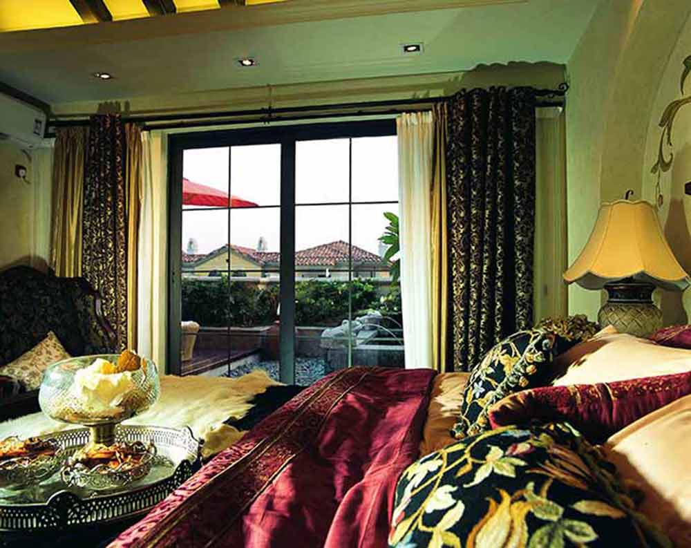 主卧室连接阳台，通透明亮。从床品到窗帘，金、黑相间的精致花纹装点出了华美而尊贵的气质。