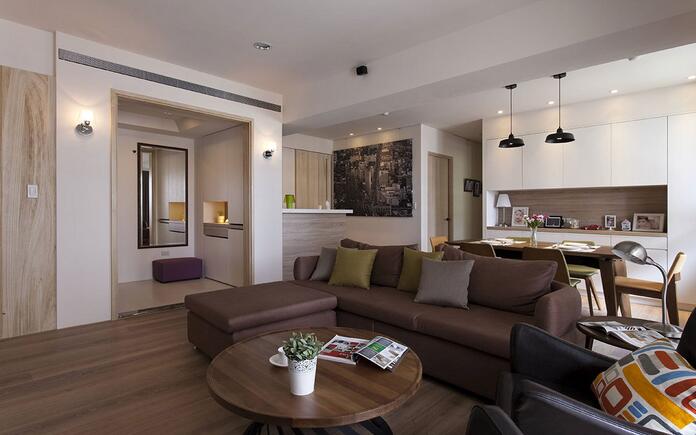 咖啡色布沙发搭配上绿色及藕色的小抱枕，让空间色彩一致并具有协调感。