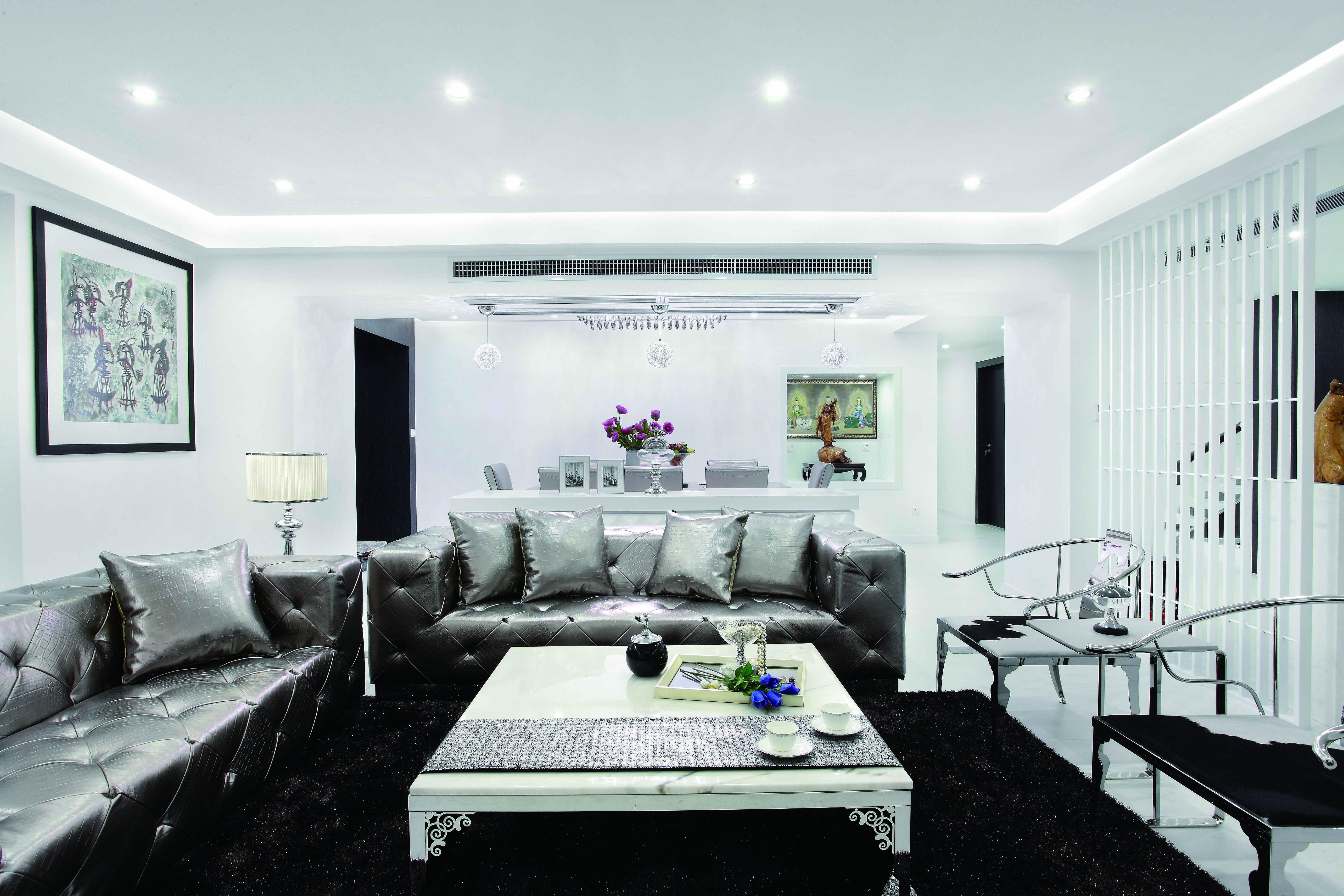 银色的皮质沙发有镜面的效果，在灯光的映衬下熠熠生辉。