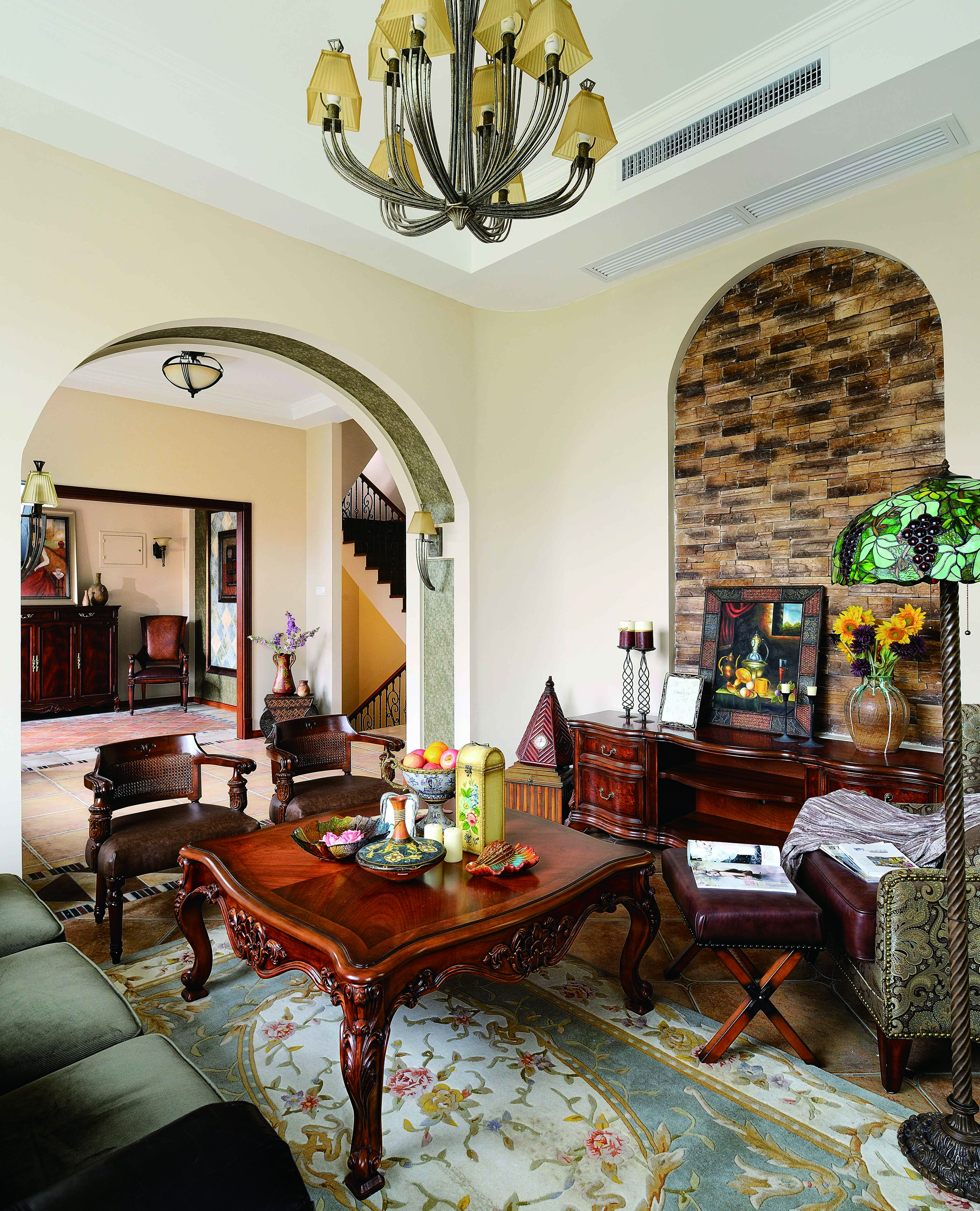 弧形门洞、木质欧式桌椅、布艺沙发和蒂凡尼的落地灯，经典的米黄色墙面将地中海风格展露无遗。