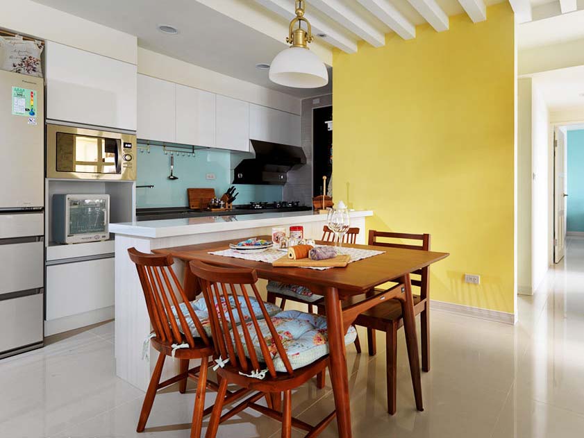 黄色的墙壁似乎是餐桌椅延伸出来的部分，连坐垫都是客厅的风格。