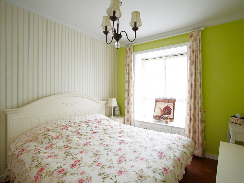 主卧漆上了鲜绿色，碎花元素运用在窗帘和床上用品上，浓浓的田园味道。