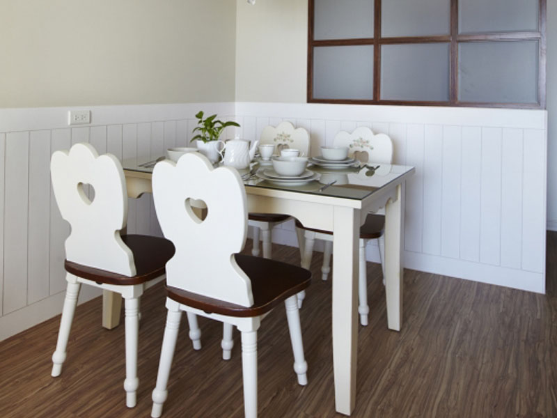 餐桌椅紧凑地布置在直角区域，墙面的三分之一的下半部分，贴上白色的竖木板，营造出美国乡村户外栅栏的进餐氛围。
