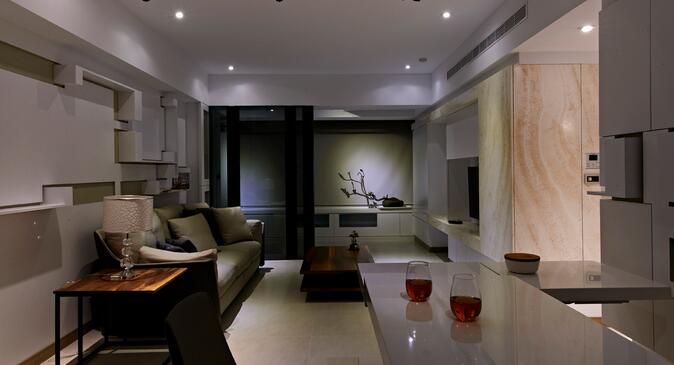 沙发背景墙与餐厅立面的造型线条相呼应，接续电视墙洞石线条，塑造走廊空间的延展性。