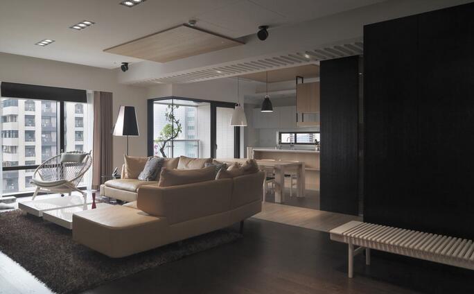 大面飘窗透过的自然光，给人通透宽敞的舒适视觉，深色地板搭配米色沙发显得简单而优雅。