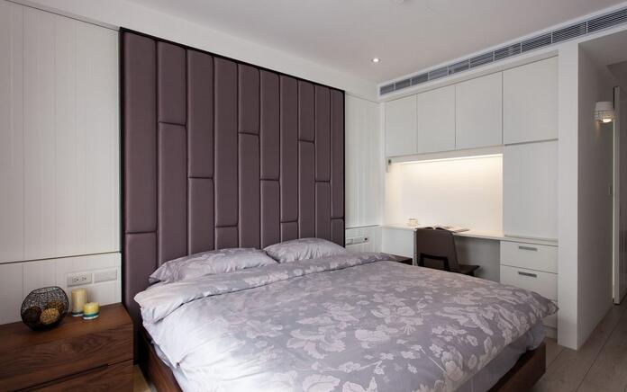 床头主墙以深紫灰色绷皮展现透光感，在简单线条的净白简约中，营造主卧低调奢华的质感。