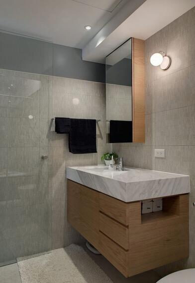 卫浴空间延续公领域的色彩，浅灰与木作体现空间内敛层次。