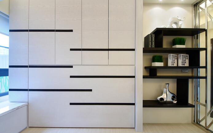 书房简单的黑白配色中，整合了收纳柜、展示柜及单人床，将空间利用到最大。