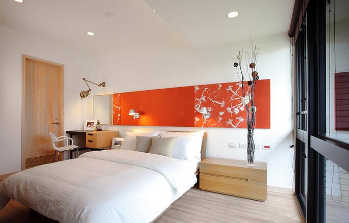 卧室立面的绷布展现橘色的鲜明色彩，搭以金属质感的壁挂灯具，体现出简约个性风格。