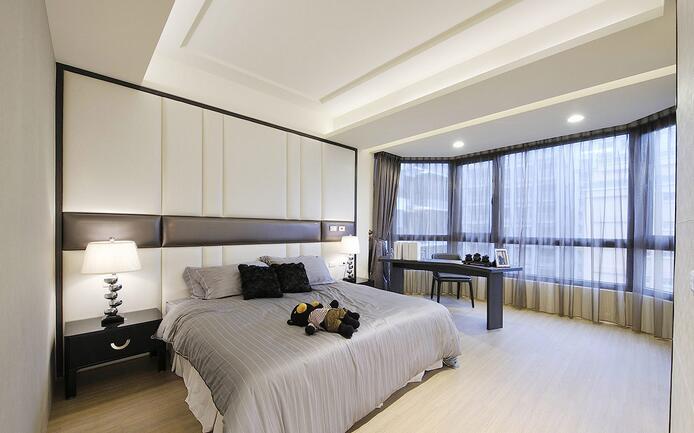 主卧空间中，床头以白色绷布展现现代时尚感，规划书桌为男主人提供阅读空间。
