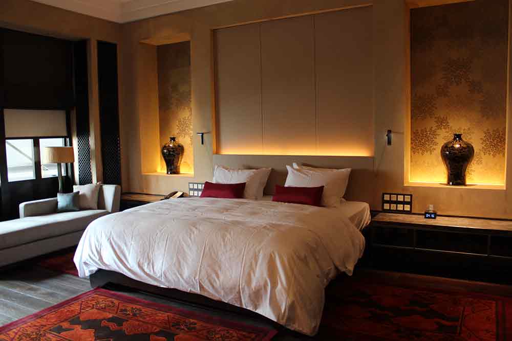 卧室环境光氛主打柔和浪漫，配合暗红色调的地毯，床头区域的黄色微光为起居打造了无比安适的环境。