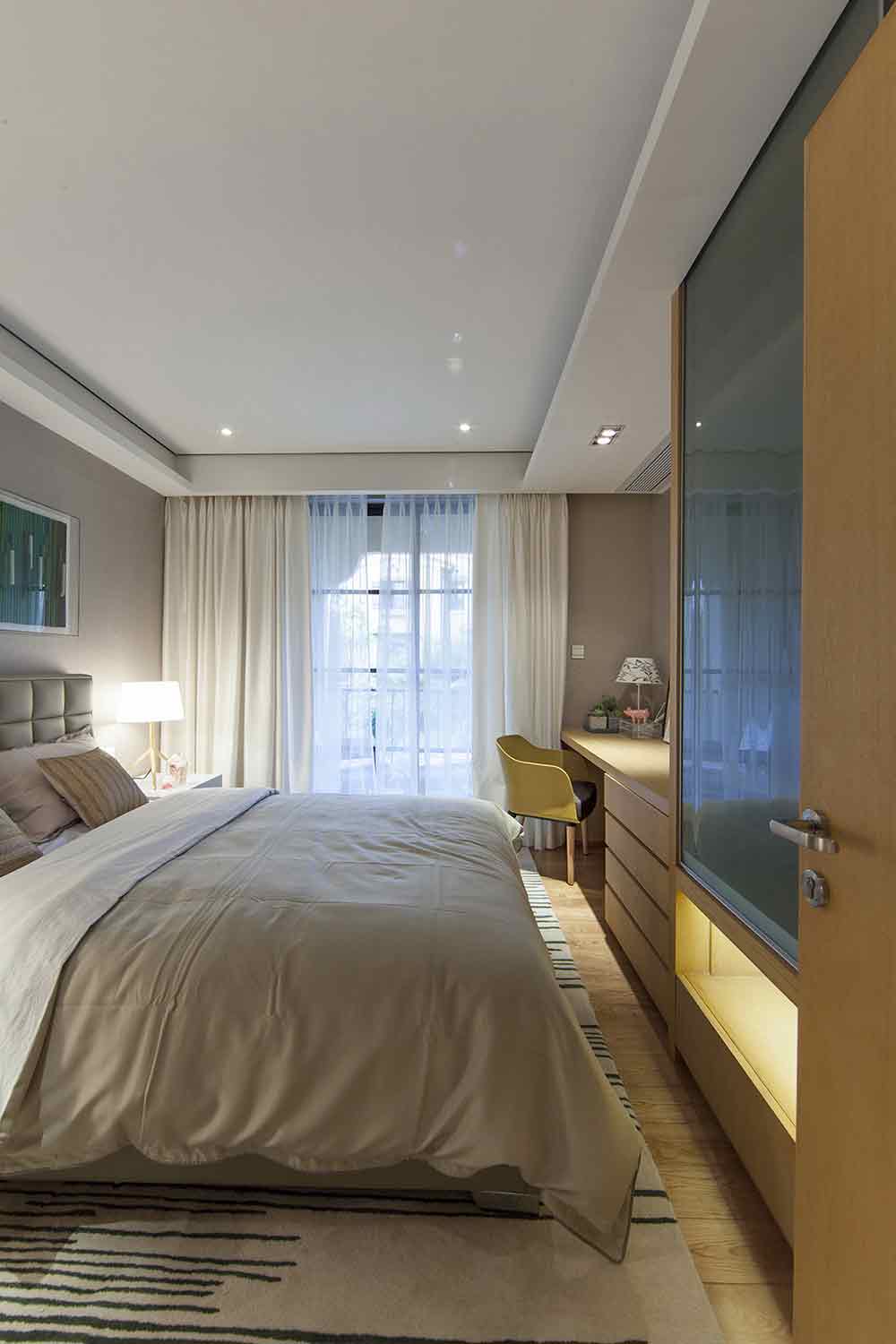 卧室的用色更为轻浅，白色双层窗帘将柔美的空间性格完美展现。床尾处一体式的书桌和衣柜设计实用功能极强。