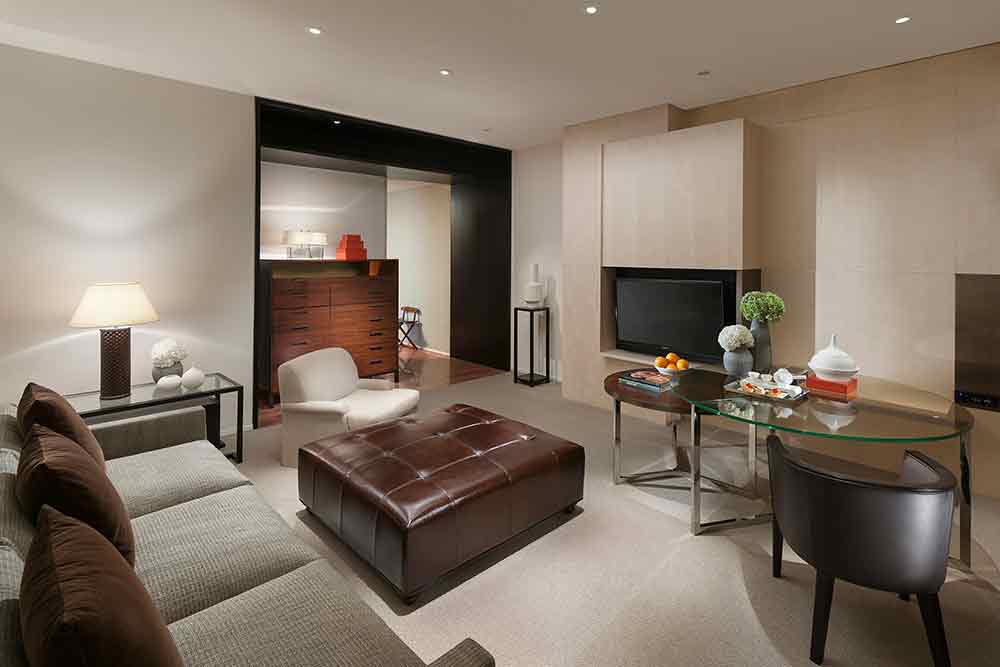 棕红色皮质沙发椅成为了客厅区域的视觉和谐，并透过同色系的收纳柜、矮桌、靠枕等实现了设计的统一性。