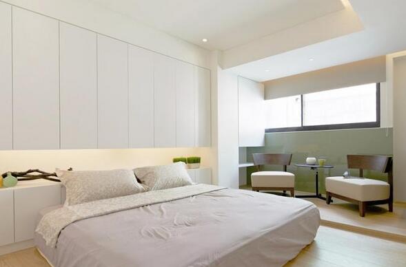 卧室床头以简洁的造型设置了具备强大收纳功能的柜体，榻榻米式的寝具风格重在主张安然和舒适的休息氛围。