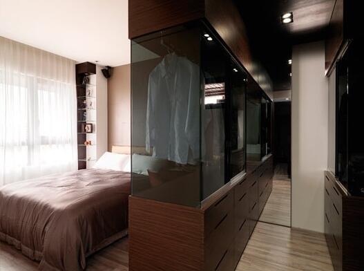 玻璃材质和木材相结合的多功能衣柜同时也作为隔断墙，分割出了一处简单而实用的更衣室。
