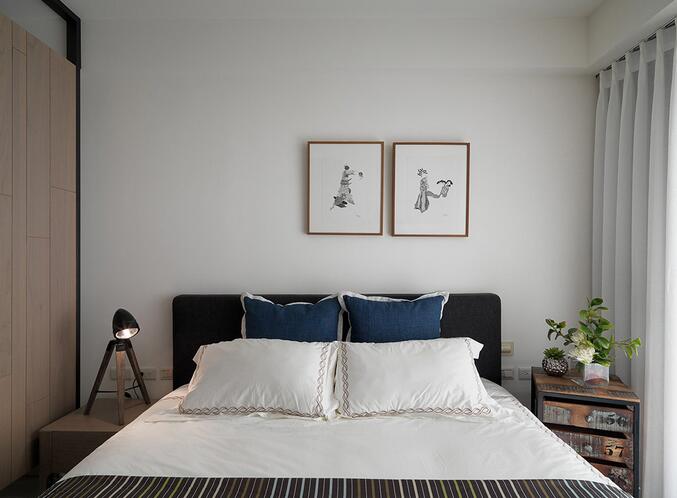床头主墙大面积的留白给人以更多想象空间，也还原了最纯粹的卧眠感受。简单的两幅挂画足以将艺术个性渲染开来。