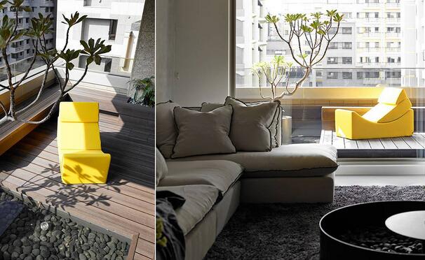 阳台以鹅卵石、木地板和颜色鲜亮的造型椅营造了闲适惬意的休憩环境，并规划出了鱼池和绿化空间。
