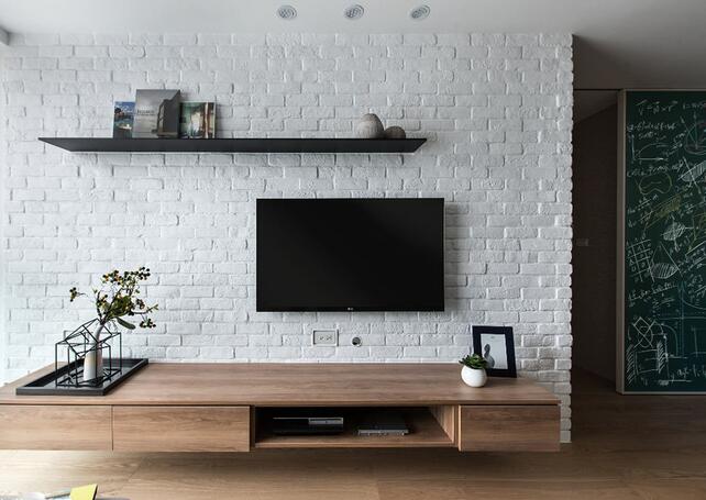 白色文化石铺饰的电视墙带有自然而踏实的质感，铁件层板和木质电视柜简约的造型时尚而实用。