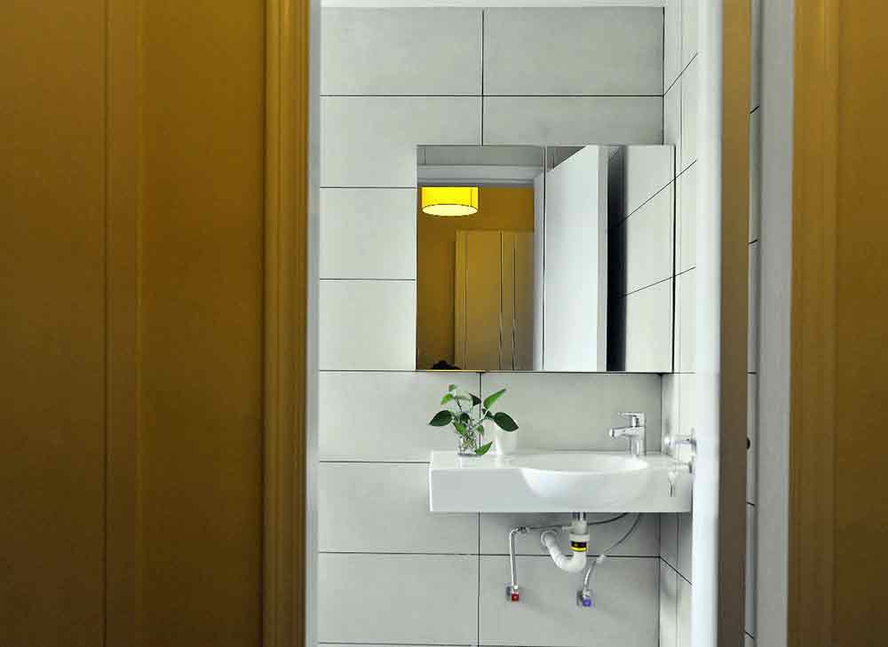 卫生间小方块造型的镜面清爽雅致，一株小小的绿植便成为了秀气的天然修饰。